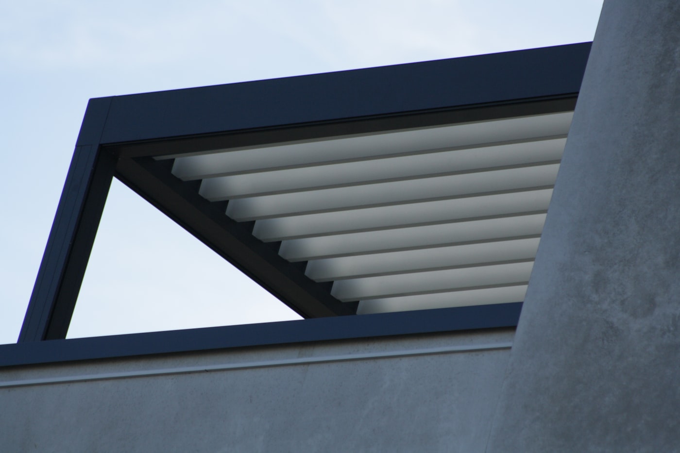 Pergola bioclimatique moderne avec lames orientables en aluminium sur une terrasse