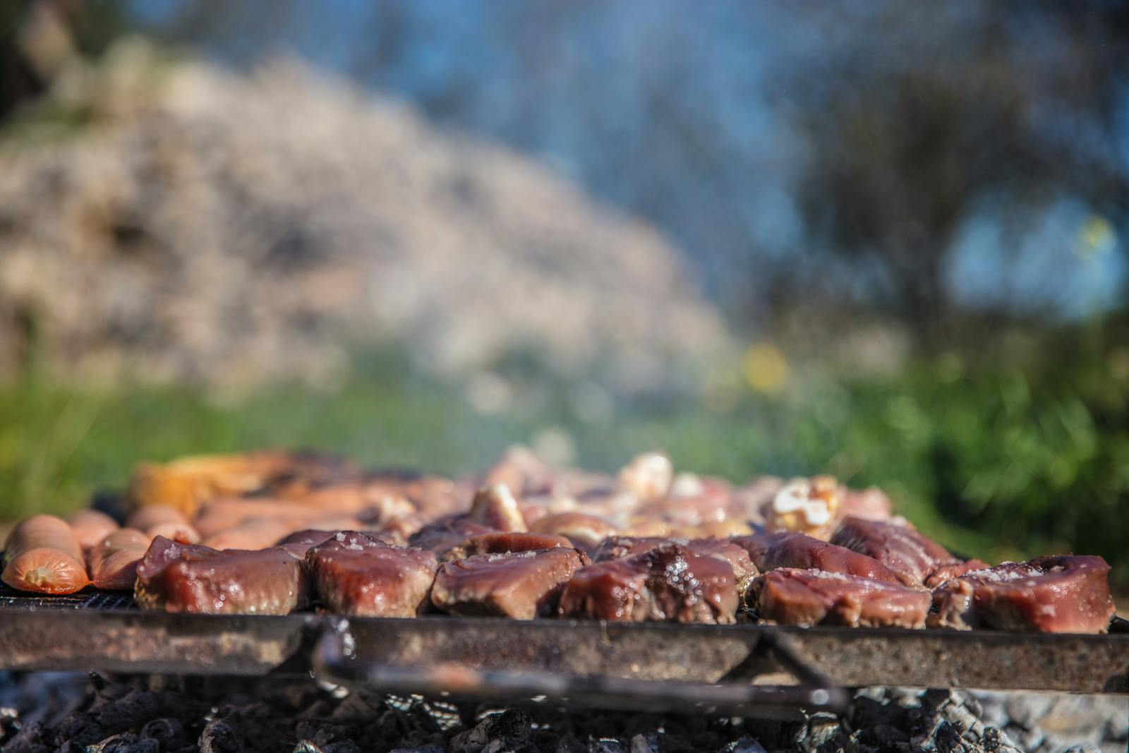 Plancha gaz allumée sur terrasse avec légumes et viande en cours de cuisson