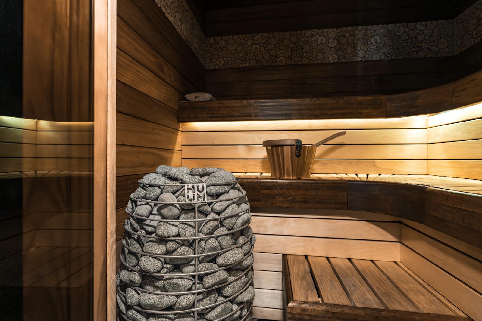 Intérieur d'un hammam vapeur avec banquettes en pierre claire et lumière douce