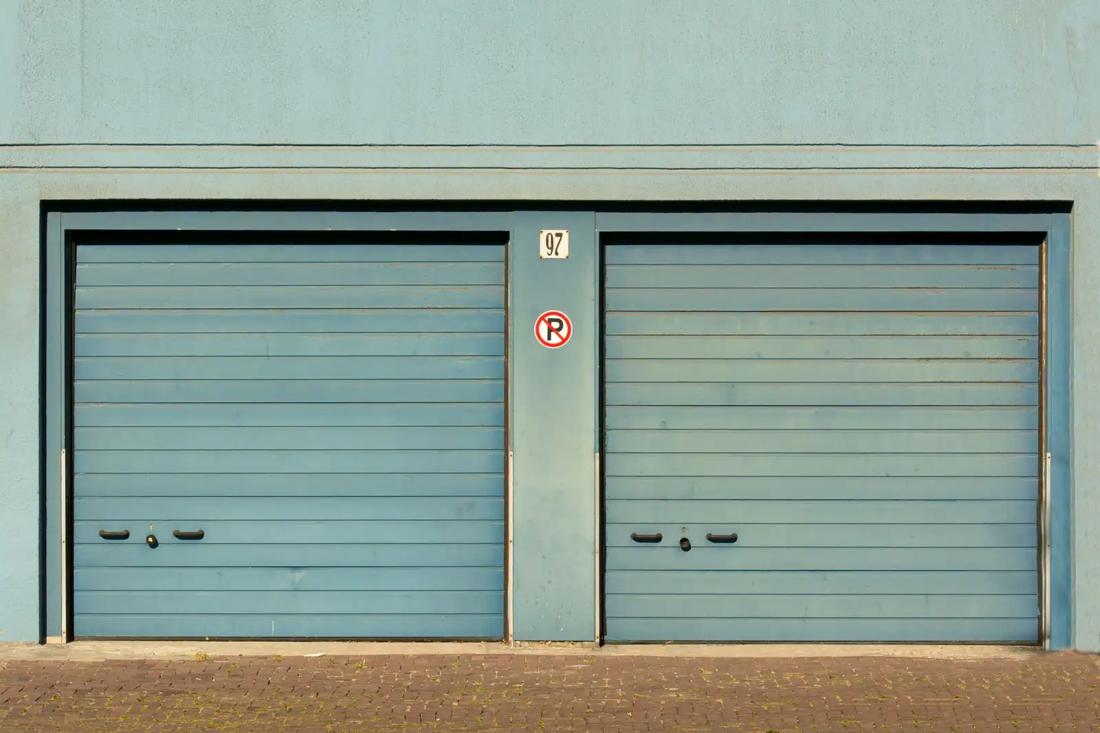 Rangée de garages fermés avec portes métalliques dans une résidence