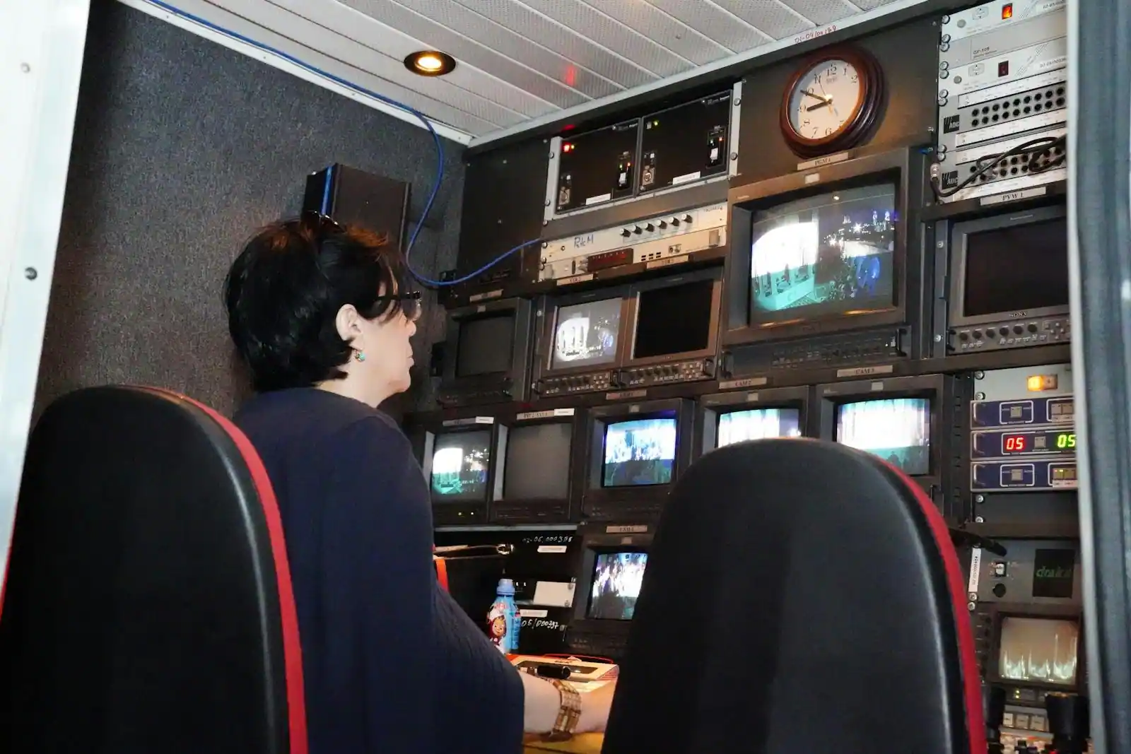 Salle de rédaction journalistique avec écrans de télévision, journaux et journalistes au travail, ambiance documentaire neutre