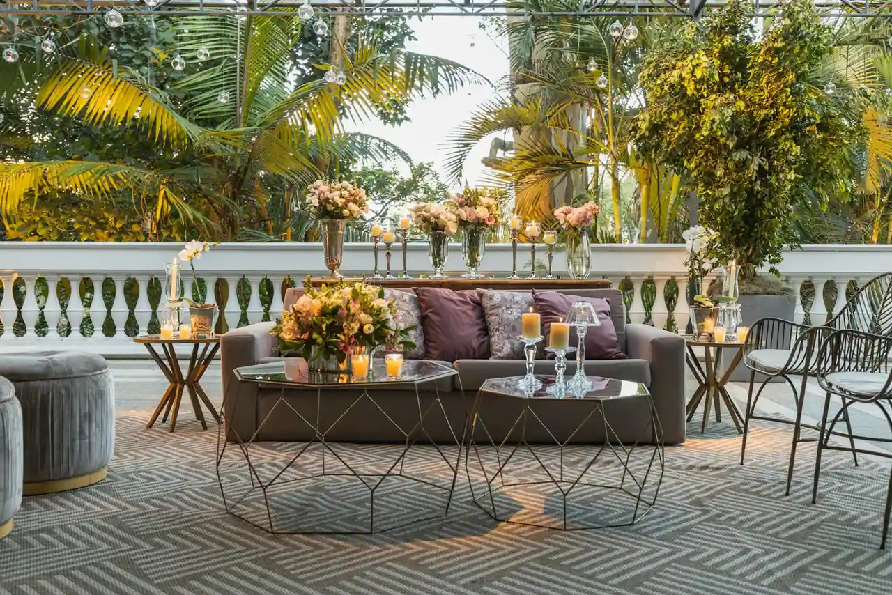 Terrasse aménagée avec table en bois, chaises, jardinières et éclairage doux en fin de journée