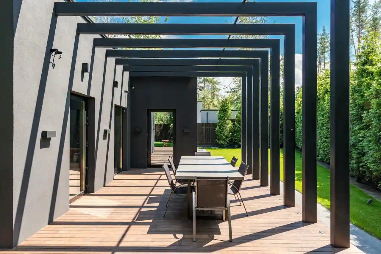 Terrasse aménagée avec salon de jardin, pergola et plantes en pots