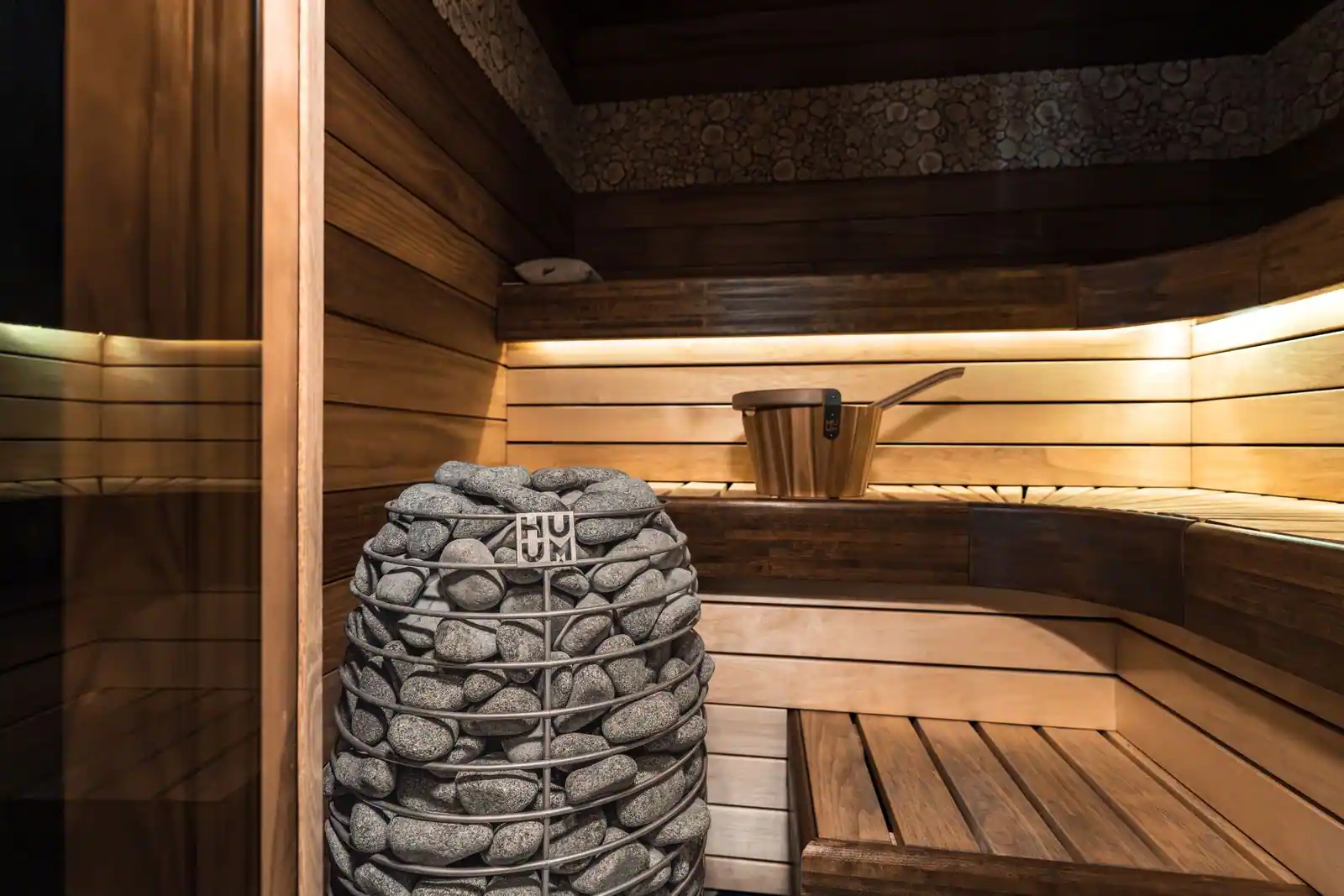 Intérieur d'un hammam vapeur avec banquettes en pierre claire et lumière douce