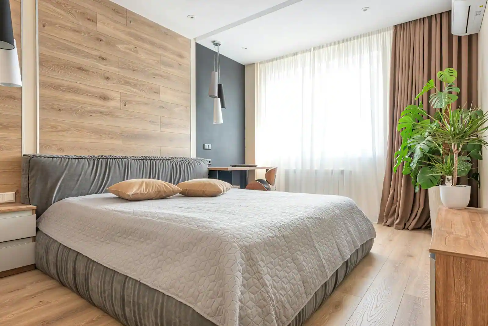Chambre adulte avec murs gris chaud, linge de lit en lin et éclairage tamisé