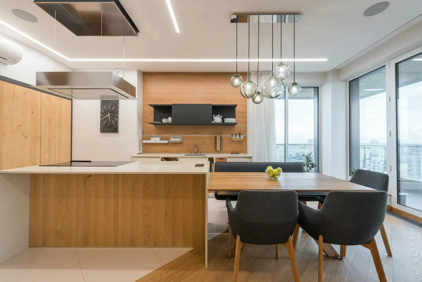 Cuisine moderne avec façades en bois clair, plan de travail en quartz et éclairage suspendu