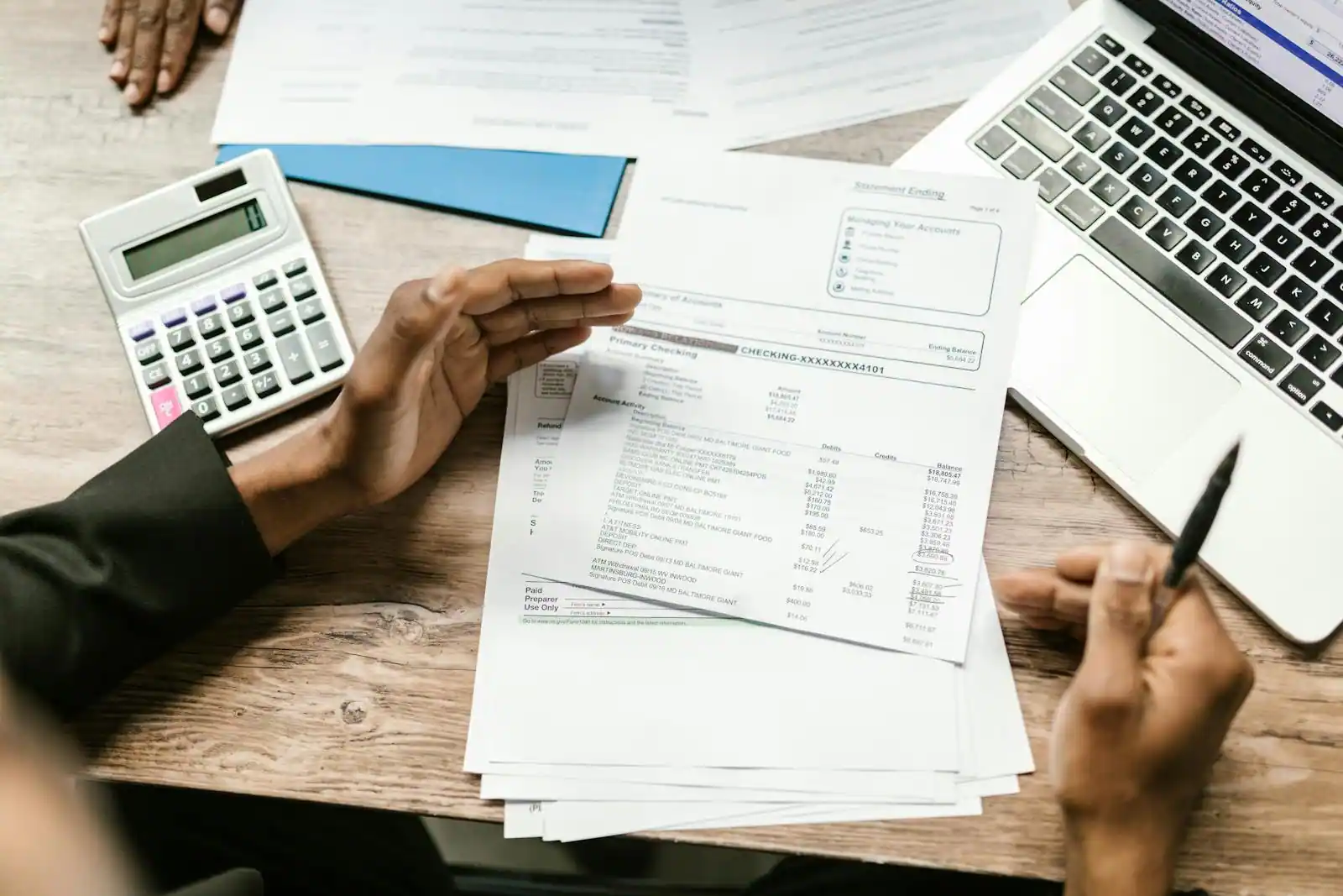 Documents financiers et calculatrice posés sur un bureau pour un calcul d'investissement immobilier