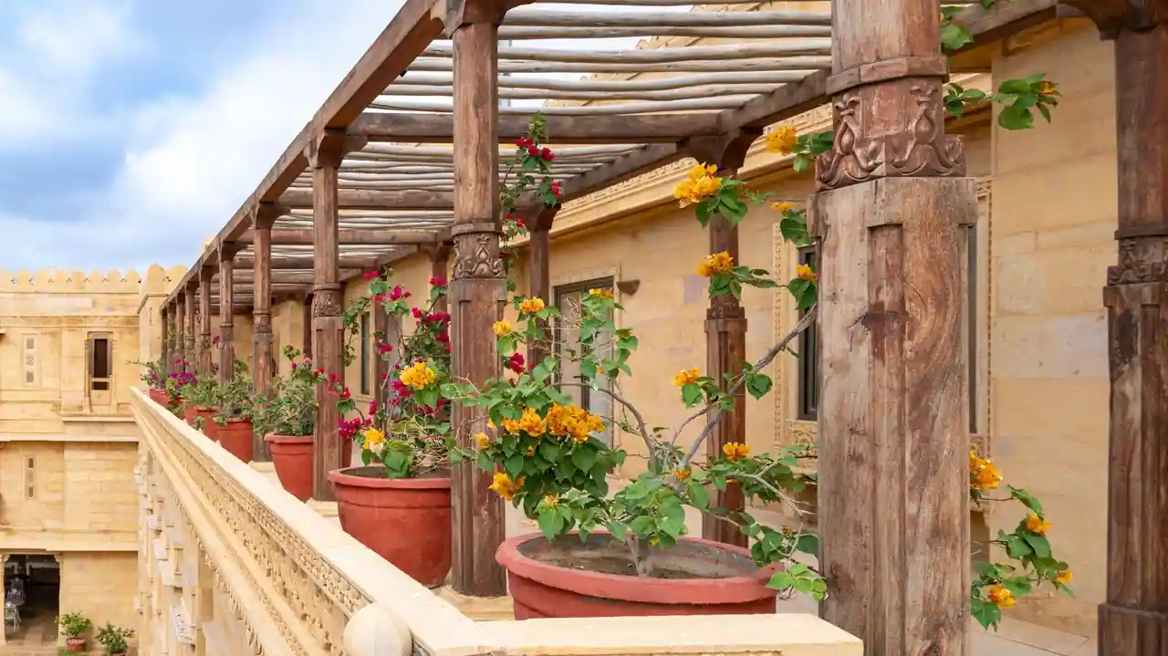 Pergola en bois construite soi-même dans un jardin, structure adossée à une terrasse avec mobilier d'extérieur