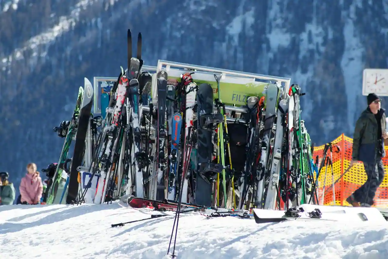 Rangée de skis colorés alignés dans un magasin de location en station de montagne