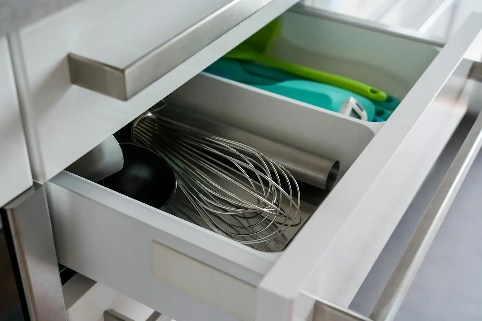 Cuisine aménagée avec colonnes de rangement et tiroirs ouverts montrant une organisation intérieure