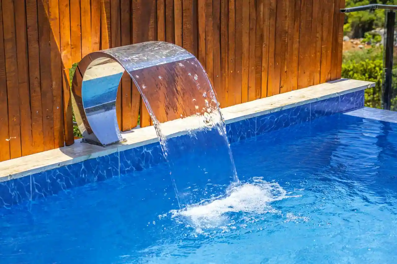 Piscine hors sol en acier installée dans un jardin, vue panoramique du bassin et de la terrasse périphérique