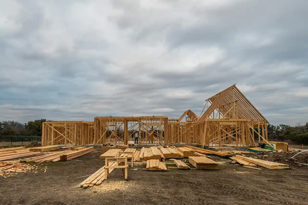 Maison neuve en construction avec murs en parpaing et charpente en bois visible