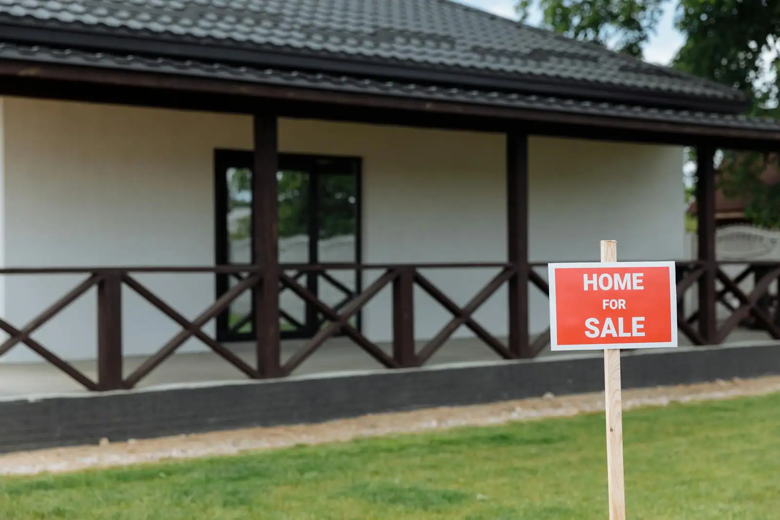 Maison avec jardin vue depuis l'extérieur avec panneau de vente immobilière