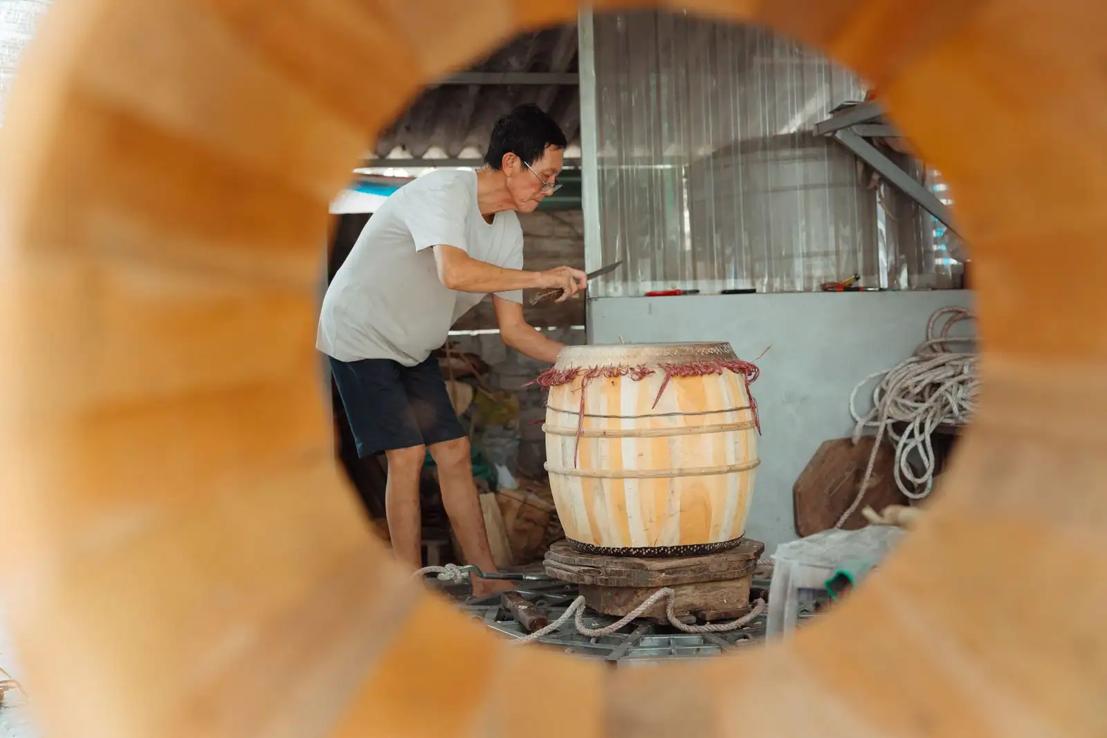 Artisan façonnant à la main un tambour traditionnel en bois dans son atelier
