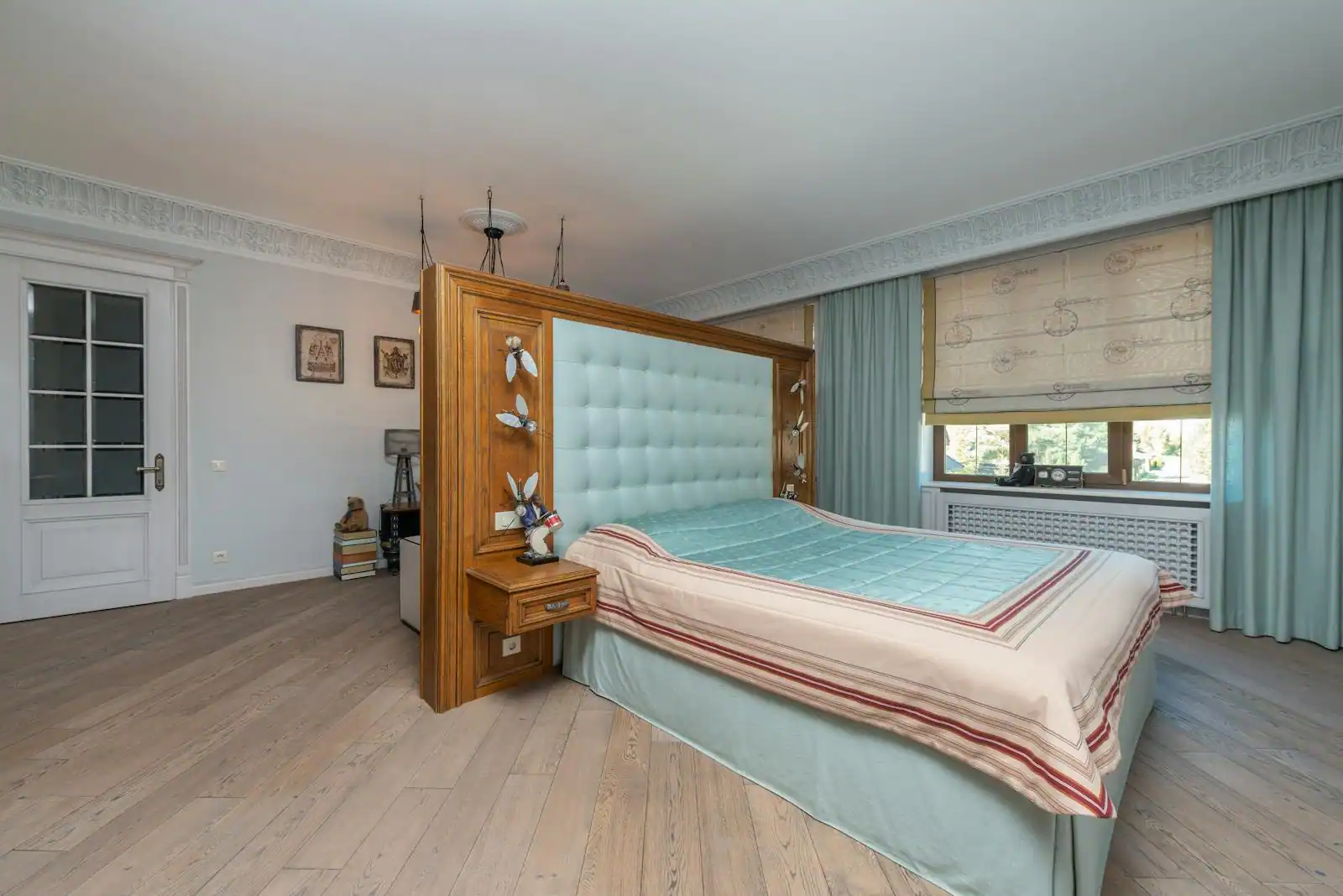 Chambre décorée et apaisante avec tête de lit capitonnée, linge doux et lampes de chevet.