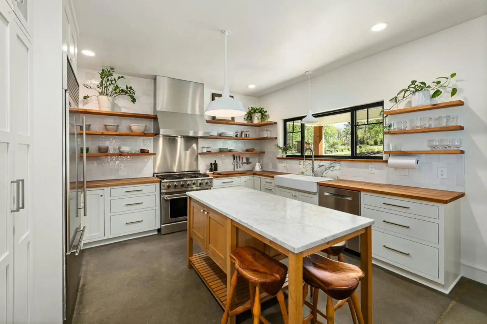Cuisine décorée avec étagères ouvertes en bois, vaisselle exposée et plan de travail dégagé.