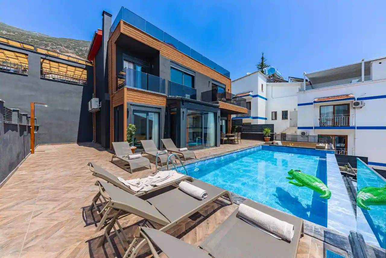 Maison de vacances avec une piscine bleue et des transats au bord du bassin