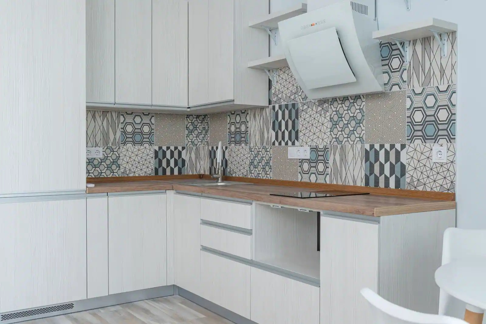 Angle d'une cuisine moderne où les meubles bas et hauts se rejoignent dans le coin