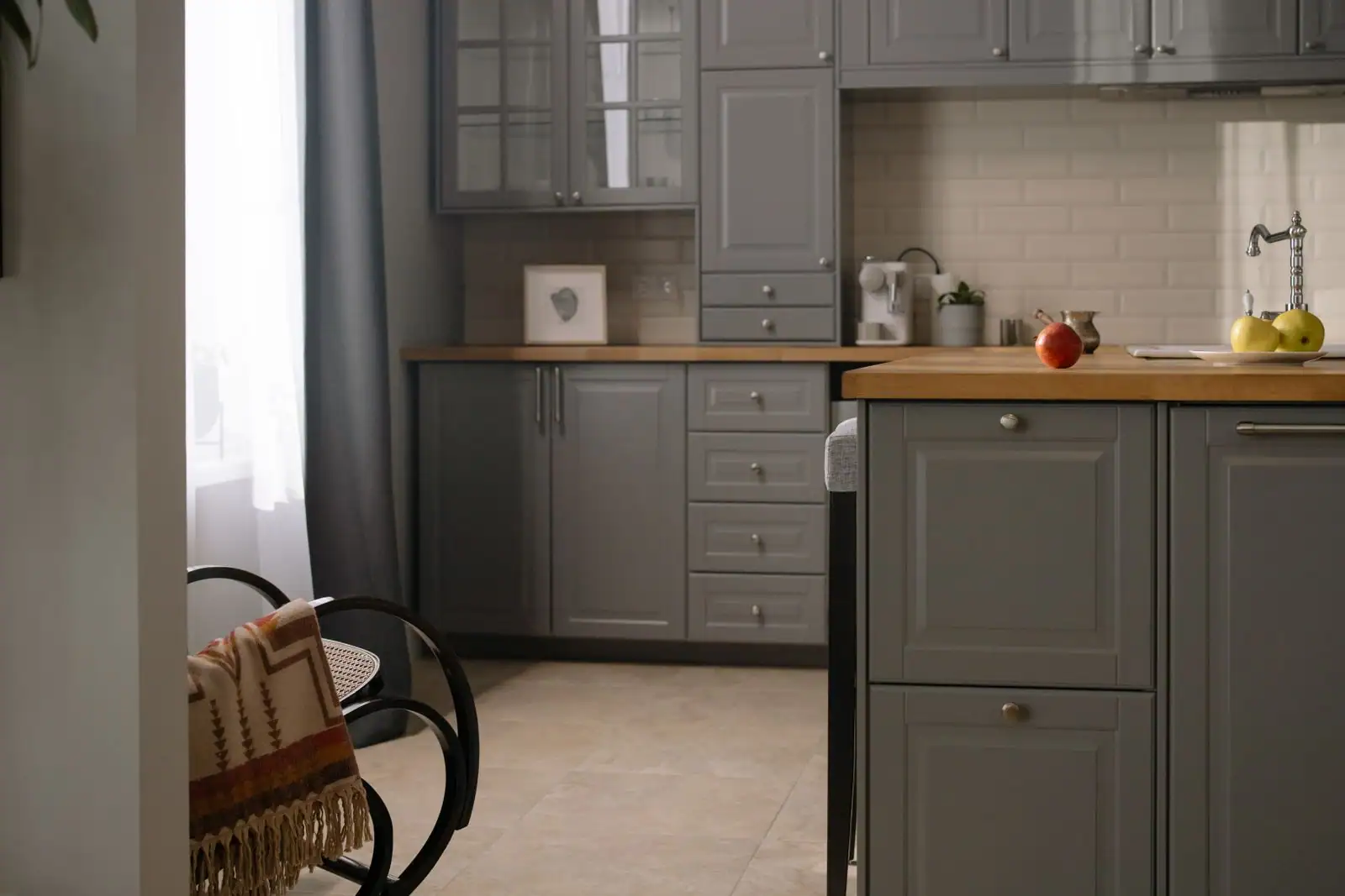 Des meubles bas gris surmontés d'un plan de travail en bois, le long du mur d'une cuisine moderne.