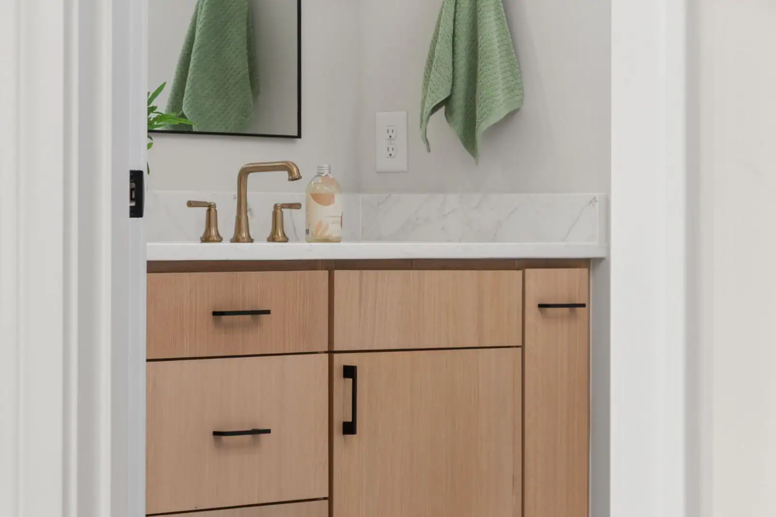 Meuble de rangement de salle de bain en bois clair avec tiroirs sous la vasque