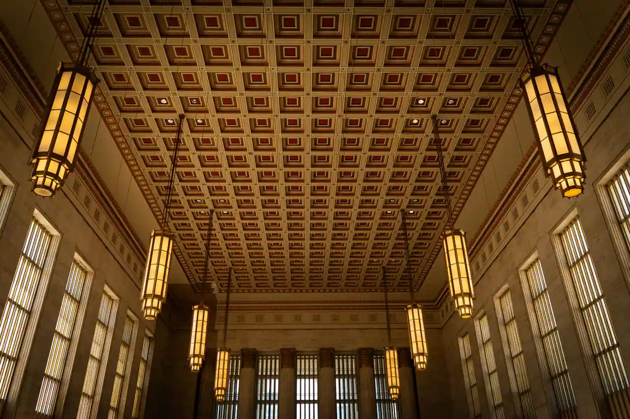 Intérieur de style Art déco : plafond à caissons géométriques et luminaires symétriques dans un grand hall
