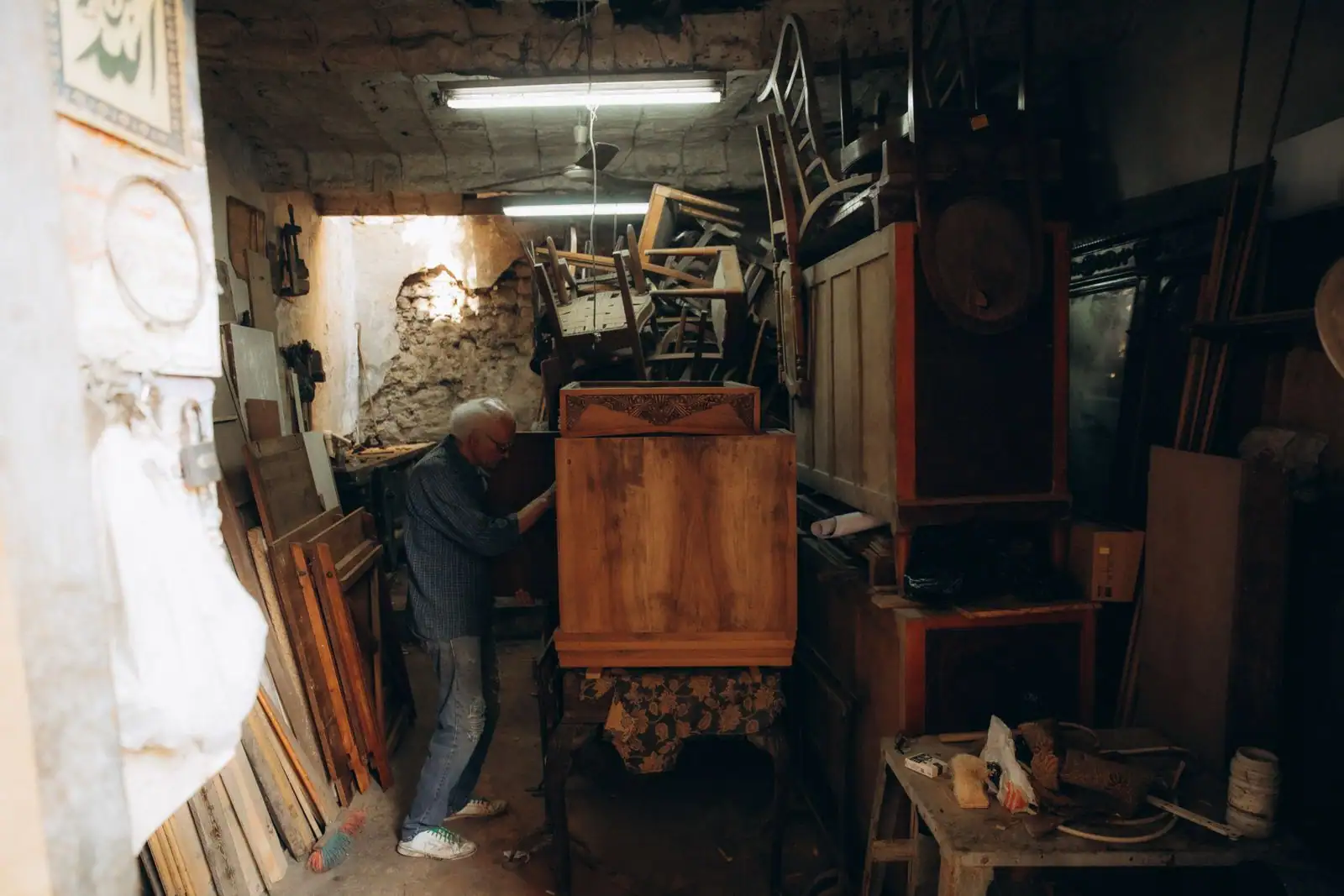 Artisan au travail sur un meuble en bois dans un atelier