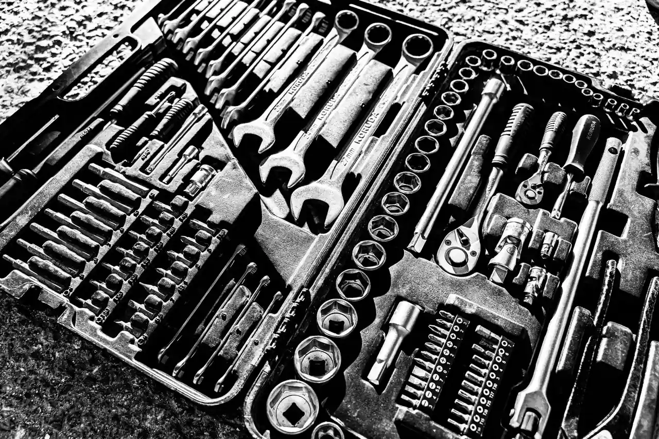 Coffret de douilles métalliques et cliquet posés dans une caisse à outils d'atelier