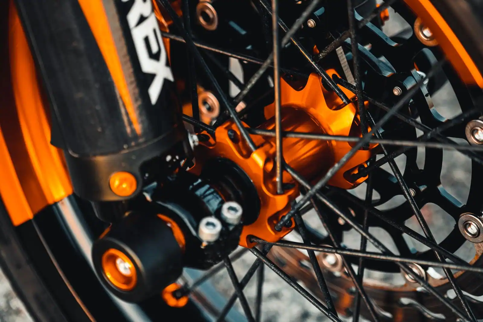 Gros plan d'une roue de moto à rayons montrant le moyeu, les rayons et le disque de frein.