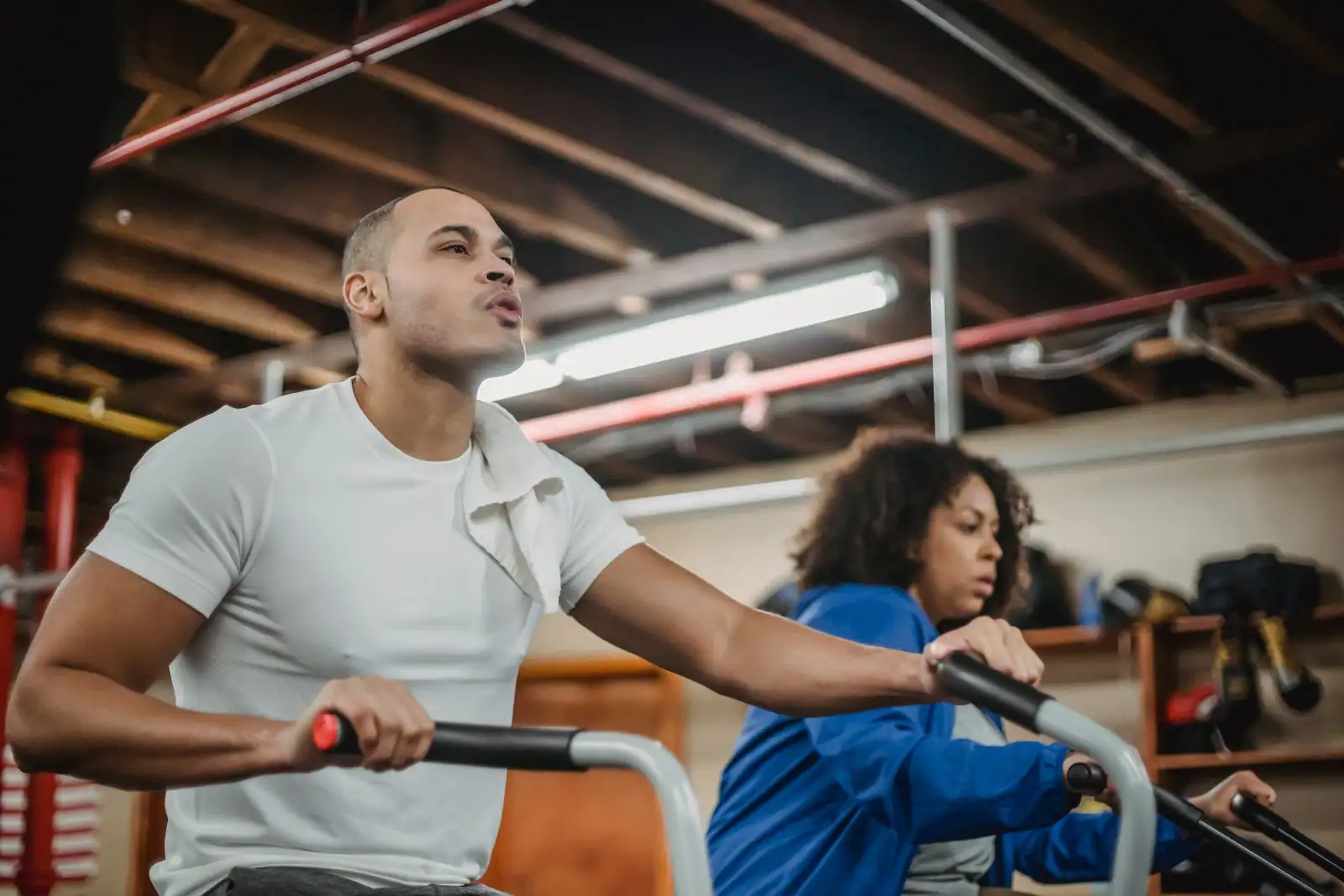 Sportifs à l'effort sur des vélos d'entraînement dans une salle de sport.