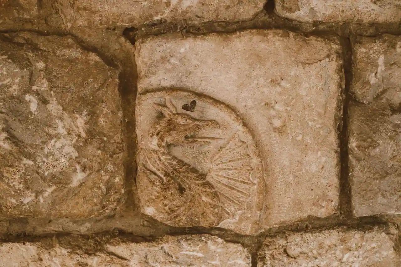 Dragon sculpté en relief sur un ancien bloc de pierre, évoquant une chambre à énigme gravée.