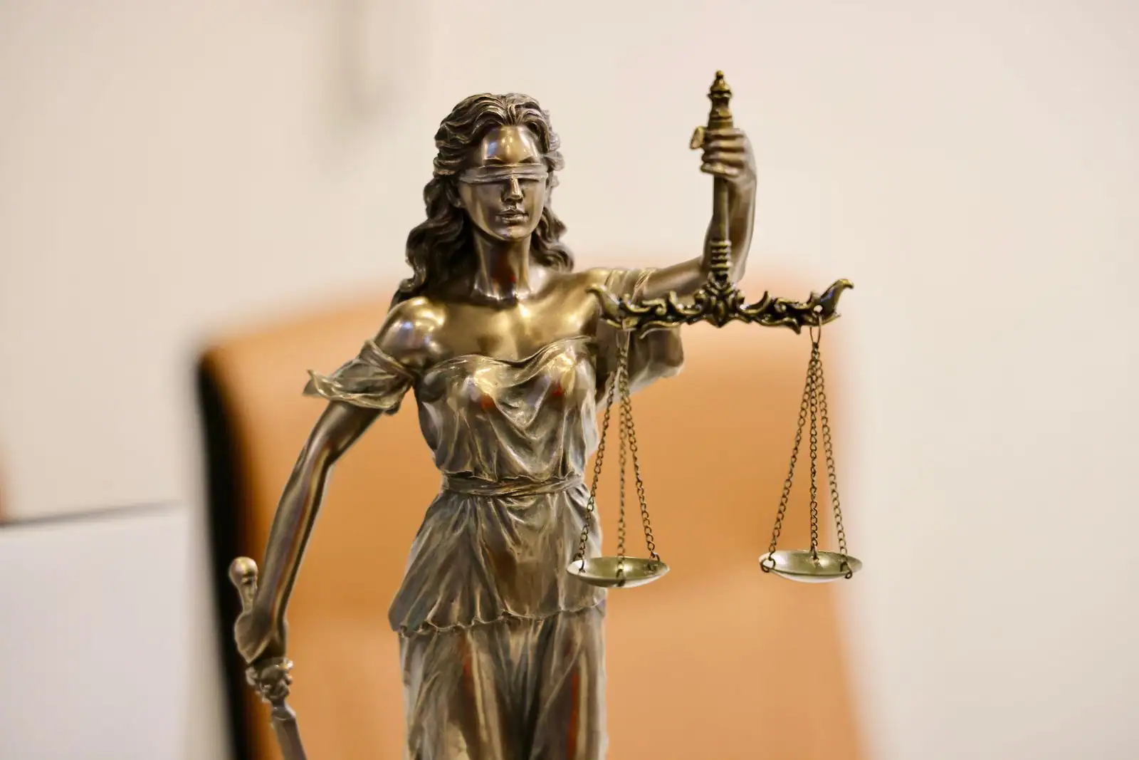Statue de la justice aux yeux bandés tenant la balance et le glaive, symbole du pouvoir judiciaire.