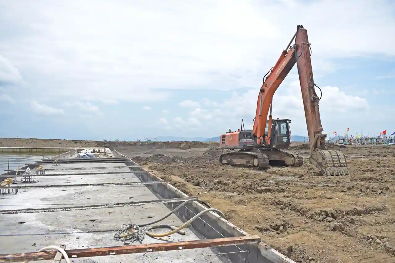 Chantier de gros œuvre : pelleteuse et fondations en béton coulées dans des fouilles