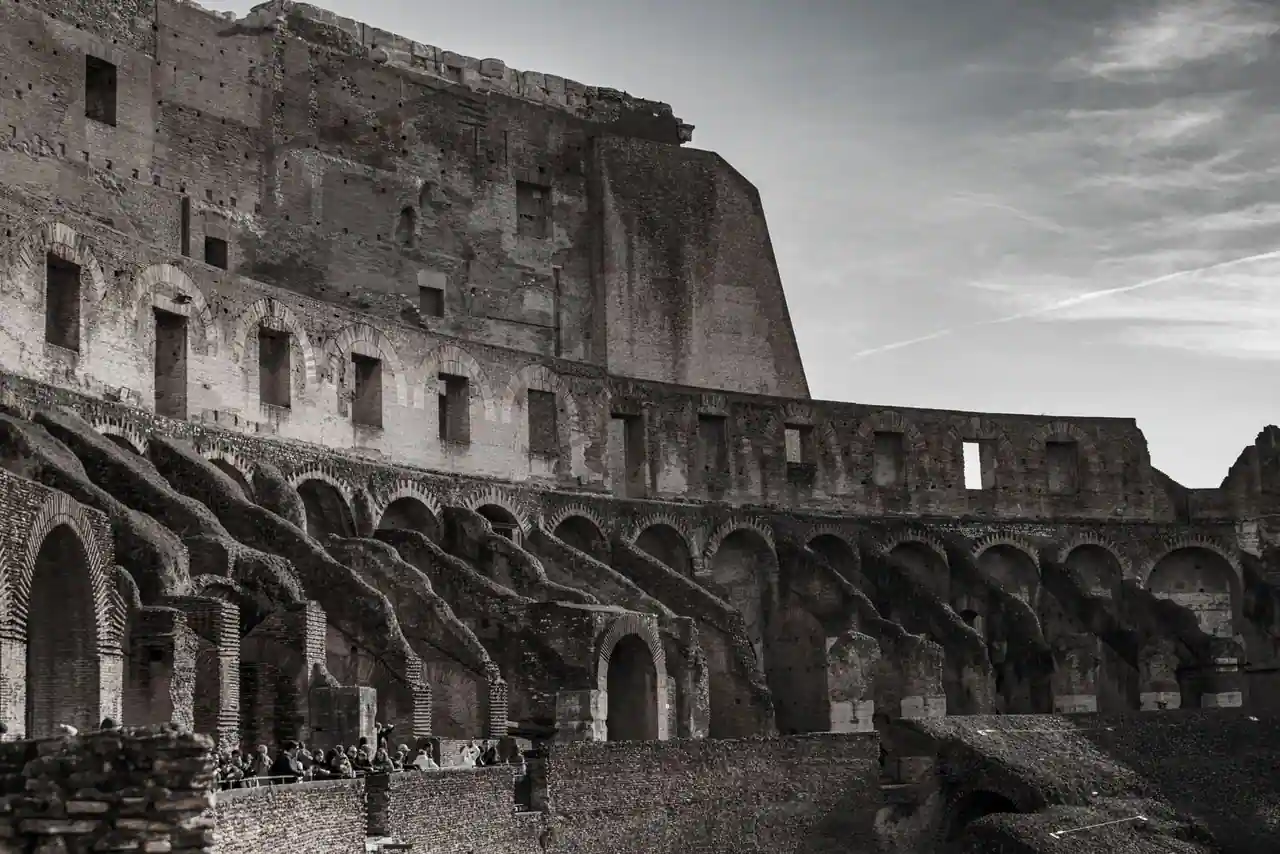 Le Colisée de Rome, façade de travertin percée de ses arches superposées, sous un ciel dégagé.