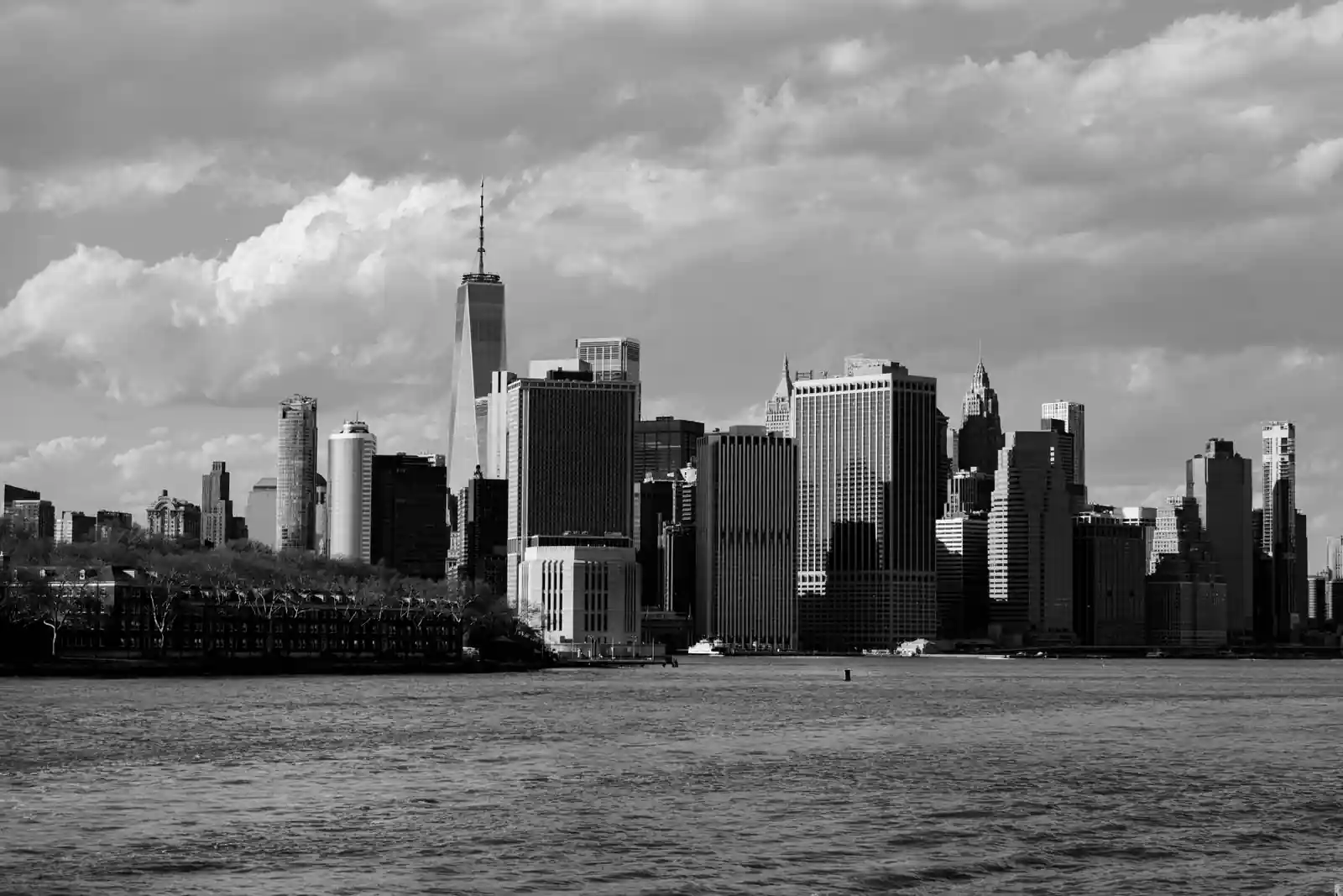 La tour du One World Trade Center dominant les gratte-ciels du sud de Manhattan, photographiés en noir et blanc.