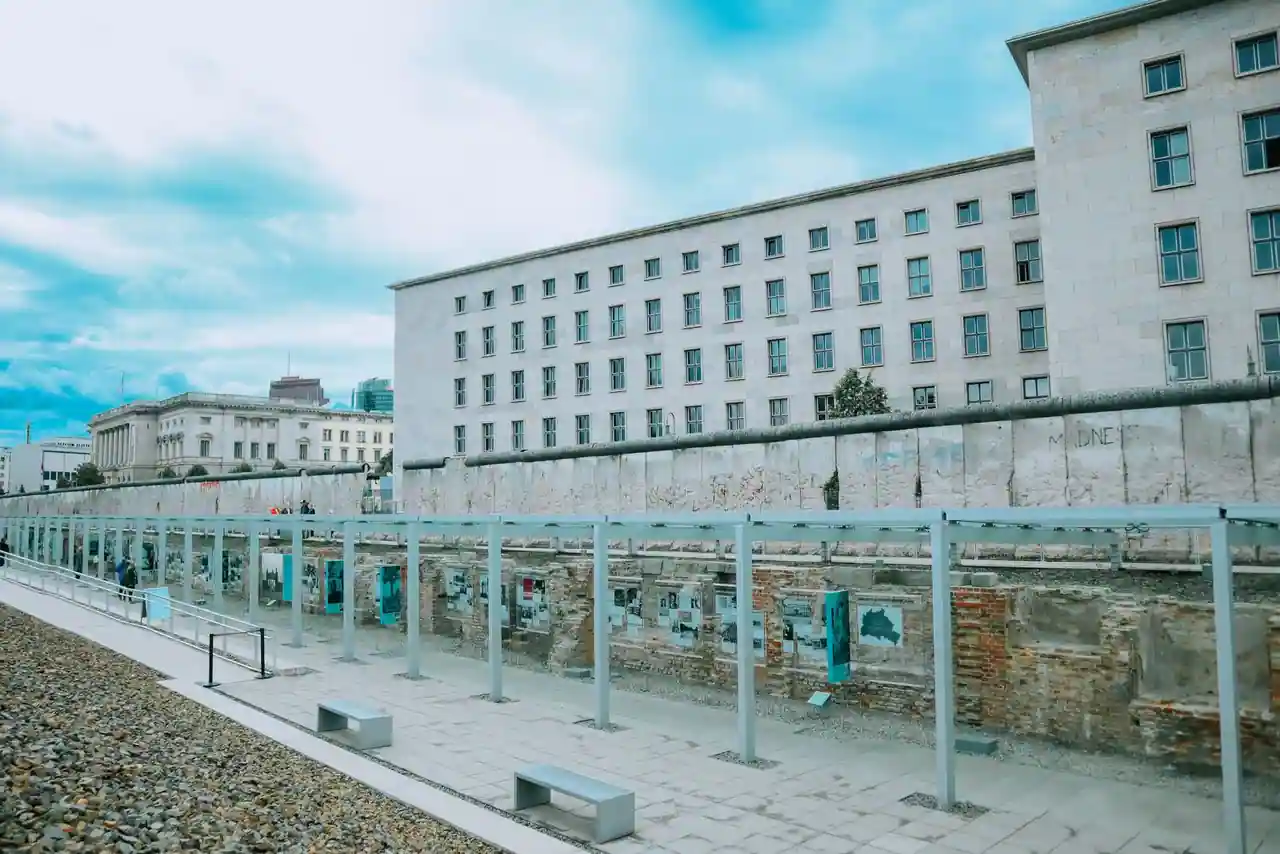 Une section conservée du mur de Berlin en béton, au sommet arrondi caractéristique, sur un site mémoriel.