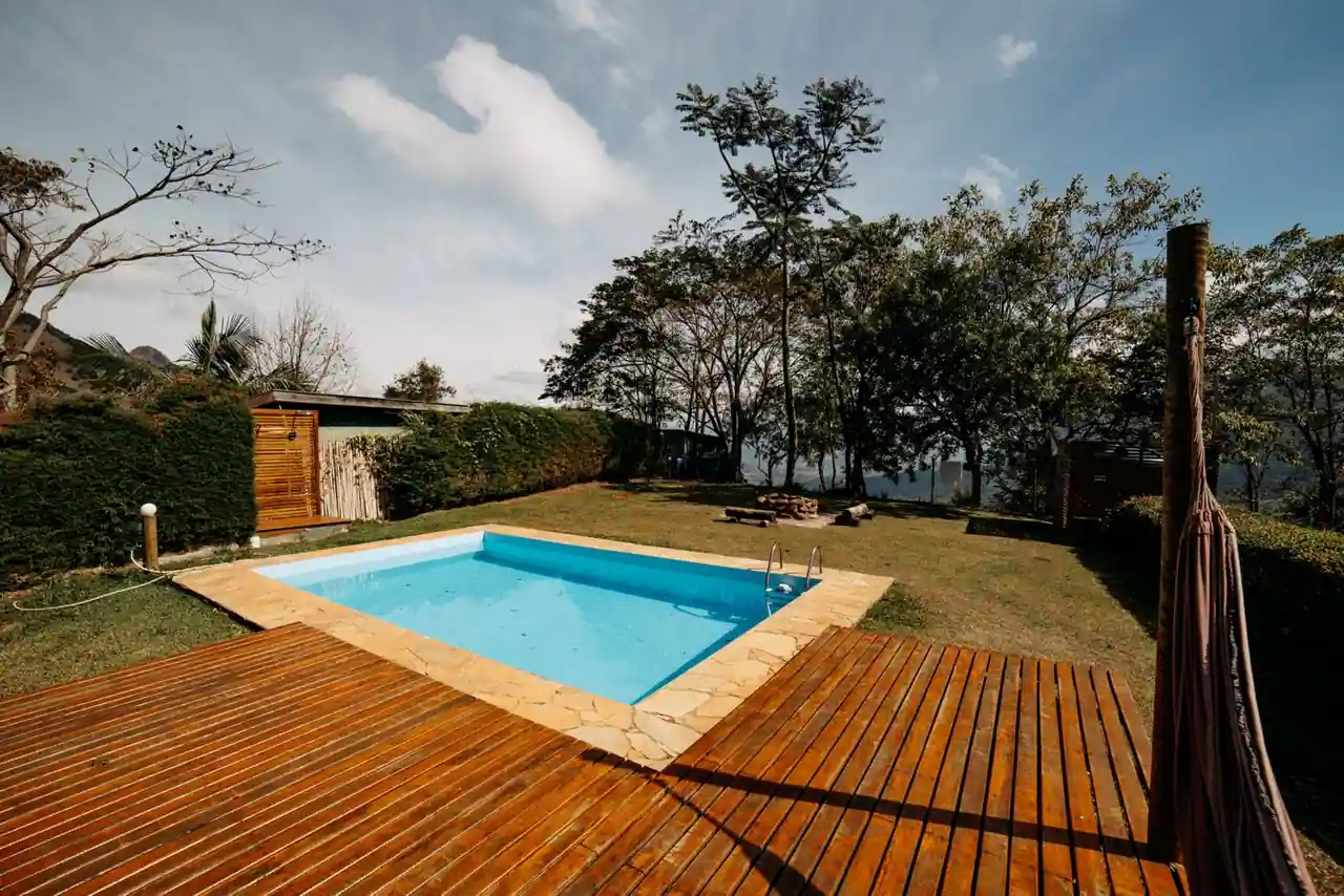 Piscine extérieure privée avec terrasse en bois dans un jardin verdoyant